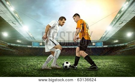 Two football players with ball in action outdoors.