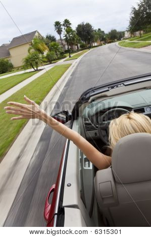 junge Frau Cabrio Steuerwagen mit Hand in der Luft