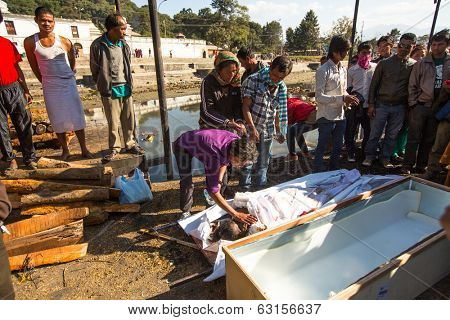 KATHMANDU, NEPAL - DEC 3, 2013: Unidentified local people during the cremation ceremony along the holy Bagmati River in Bhasmeshvar Ghat at Pashupatinath temple in Kathmandu.