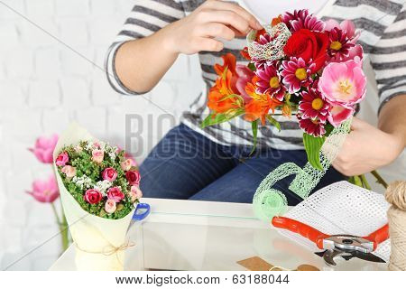 Female hands composing beautiful bouquet, close-up. Florist at work. Conceptual photo