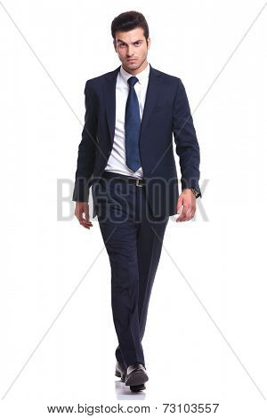 Full length picture of a elegant business man walking on white background, looking at the camera