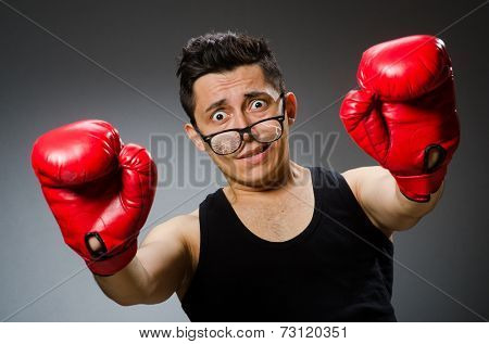 Funny boxer with red gloves against dark background