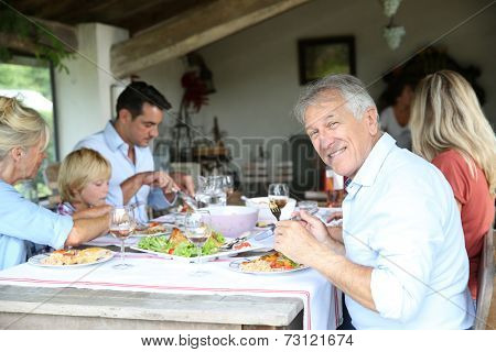 Family having summmer lunch in country house