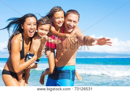 Happy Mixed Race Family of Four Playing and Having Fun on the Beach. Tropical Beach Family Vacation.