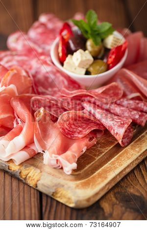 meat antipasti Platter of Cured Meat,   jamon, olives, sausage, salami  on old wooden board