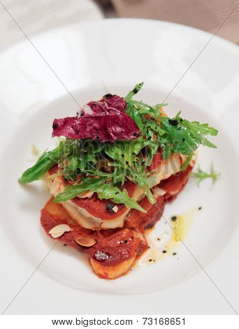 Fish and potatoes fried with romesco sauce in plate