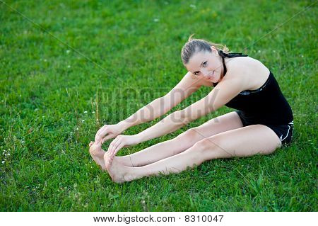 Cute adolescente s'étend ses jambes sur une grasss vert