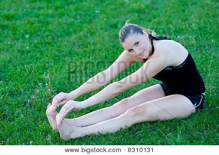 Cute adolescente s'étend ses jambes sur une grasss vert