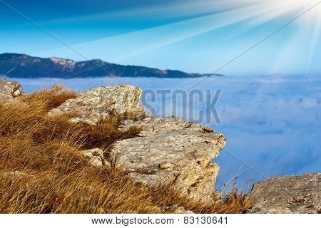Scene with stones in mountains over clouds