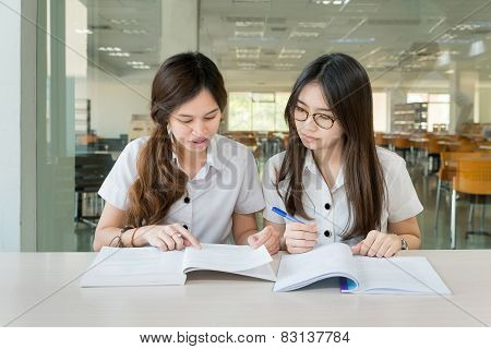 Two Asian Students Studying Together At University