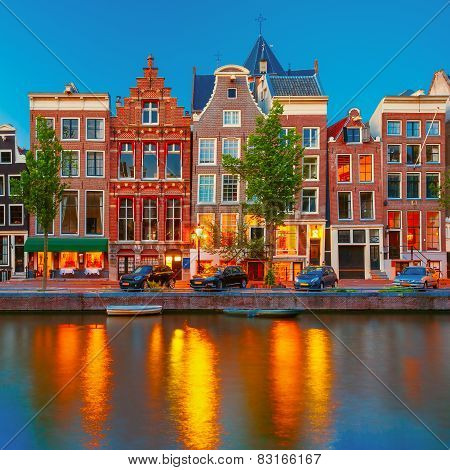 Night city view of Amsterdam canal with dutch houses