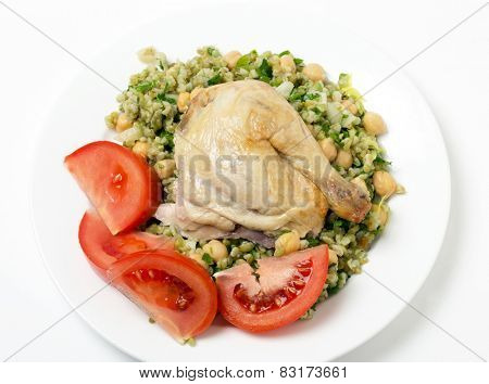 Freekeh salad with chickpeas, onion, parsley, celery, and a lemon juice and olive oil dressing, and a chicken leg with tomato