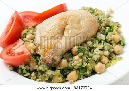 Freekeh salad with chickpeas, onion, parsley, celery, and a lemon juice and olive oil dressing, and a chicken leg with tomato