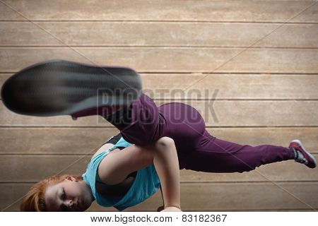 Pretty break dancer against wooden surface with planks
