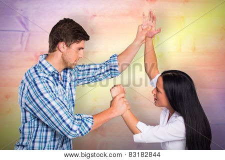 Aggressive man overpowering his girlfriend against yellow and purple planks