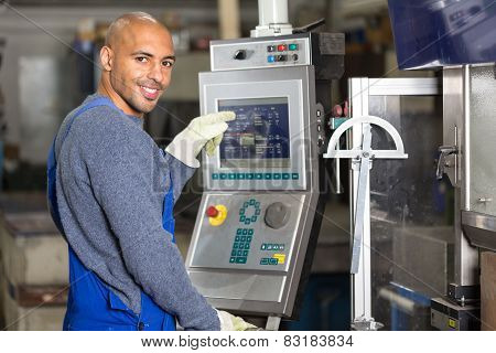 Worker Operating A Machine With Control Panel
