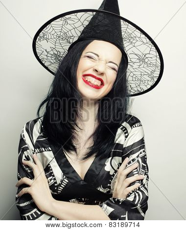 Funny Witch. Young happy woman with canival hat. Studio shot.