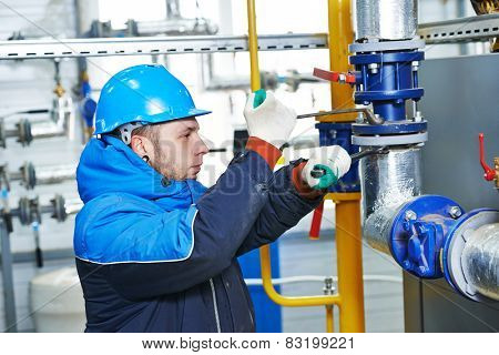 industrial heat engineer worker plumber at boiler room installation