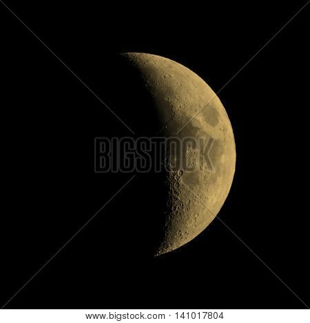 First quarter moon over dark black sky seen with a telescope from northern emisphere at night vintage sepia