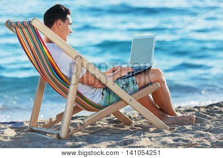 business man working with tablet on the beach