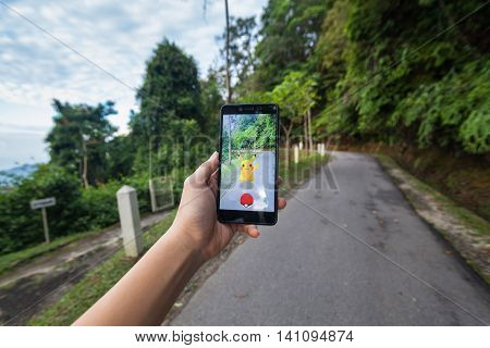 California, United States - July 23 2016 : Hand holding a cellphone to play Pokemon Go with blur background