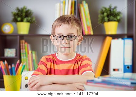 School Boy At Classroom Desk Making  Schoolwork