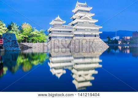 Matsumoto Castle (matsumoto-jo) Historic Landmark At Night With Beautiful Reflection In Water.