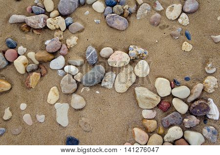 Beautiful sand background with pebbles. Close up view beach sand background. Sandy texture with stones. Brown sand. Background from fine sand. Summer concept. Top view.