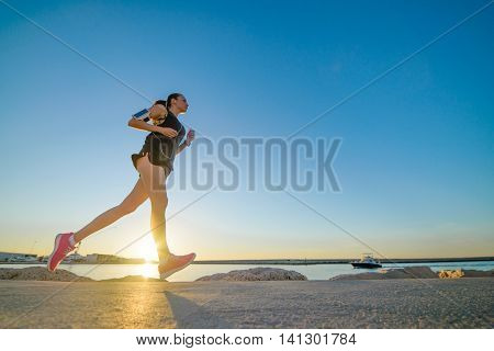 Young Sporty Girl Running Alone At Beautiful Sunset On The Beach
