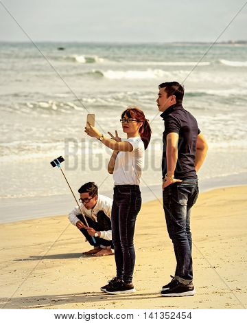 Young People Using Selfie Stick In China Beach In Danang