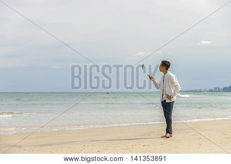 Young Fellow Using Selfie Stick In China Beach In Danang