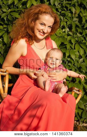 Portrait of beautiful young mother sitting with baby vertical