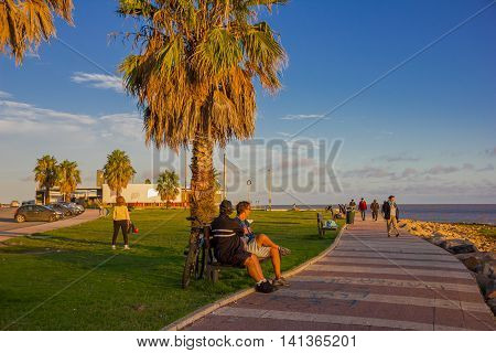 MONTEVIDEO, URUGUAY - MAY 04, 2016: nice sunset at the becah, some people enjoying the sun light and a nice blue sky as background.