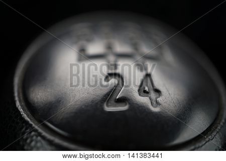 Macro detail of a black knob of a used manual shift gear (gear stick) in the aged vehicle