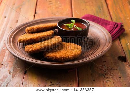 Indian chat item aloo or aalu tikki or tikiya or fried potato cake also known as ragda patties served with tomato ketchup, selective focus