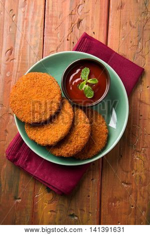 Indian chat item aloo or aalu tikki or tikiya or fried potato cake also known as ragda patties served with tomato ketchup, selective focus