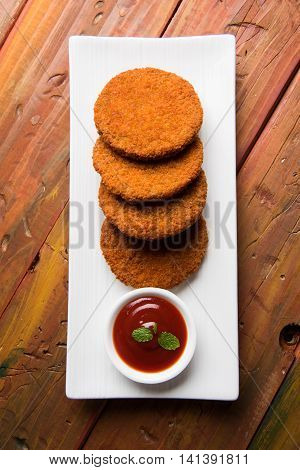 Indian chat item aloo or aalu tikki or tikiya or fried potato cake also known as ragda patties served with tomato ketchup, selective focus