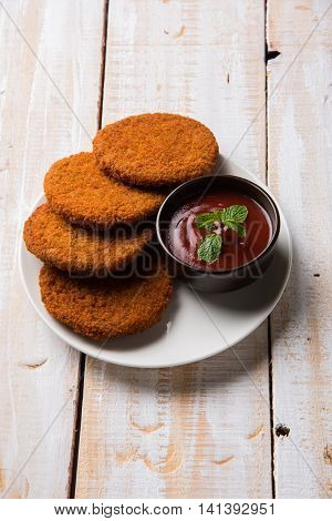 Indian chat item aloo or aalu tikki or tikiya or fried potato cake also known as ragda patties served with tomato ketchup, selective focus