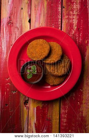 Indian chat item aloo or aalu tikki or tikiya or fried potato cake also known as ragda patties served with tomato ketchup, selective focus