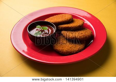 Indian chat item aloo or aalu tikki or tikiya or fried potato cake also known as ragda patties served with tomato ketchup, selective focus