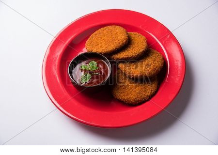 Indian chat item aloo or aalu tikki or tikiya or fried potato cake also known as ragda patties served with tomato ketchup, selective focus