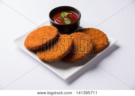 Indian chat item aloo or aalu tikki or tikiya or fried potato cake also known as ragda patties served with tomato ketchup, selective focus