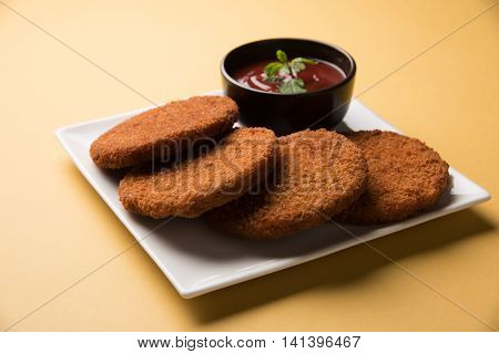 Indian chat item aloo or aalu tikki or tikiya or fried potato cake also known as ragda patties served with tomato ketchup, selective focus