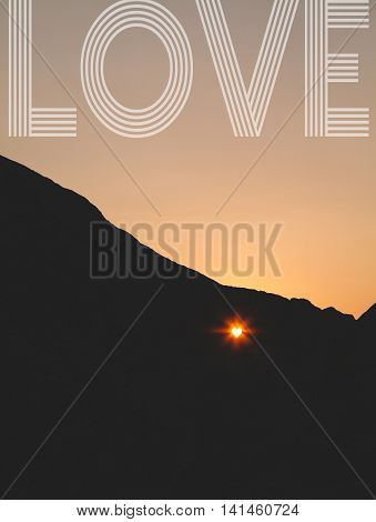 Sunet through the heartshaped hole in the cliff with love sign