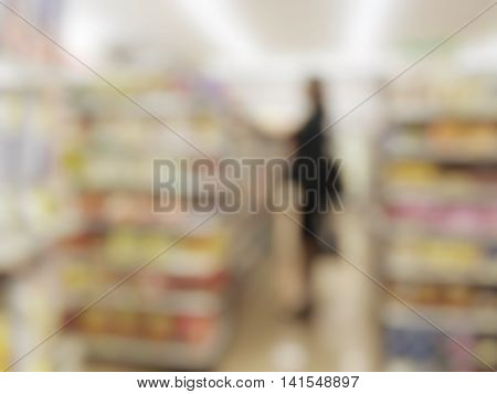 Blurred supermarket and woman shopping in the mall .