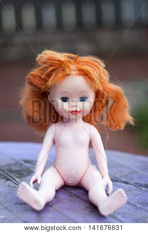 doll thrown in the rain looking for the owner.