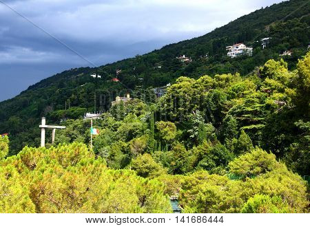 A mountain landscape with a village in Trieste Italy with a flag before storm