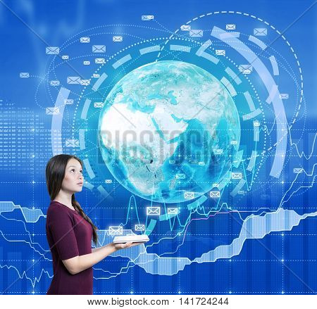 Woman holding tablet. Image of Earth and e-mail icons emerge from it. Charts on background. Concept of internet use during work and its benefit for business.