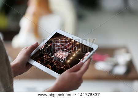 Woman's hand tablet on blurred background using. Spotlight with laser rays on screen