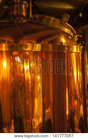 Large copper container for whisky many reflections of light.